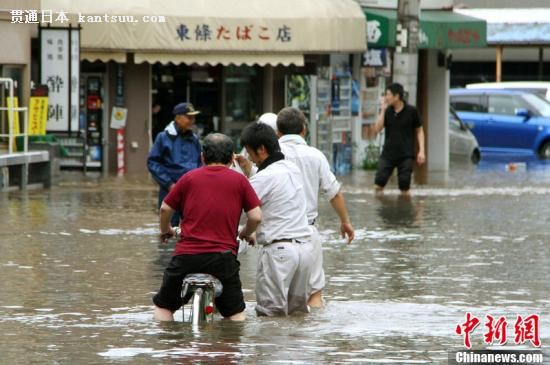 资料图:当地时间2012年7月12日,日本熊本遭遇强降雨后发生河水泛滥、塌方等灾害,图为民众在遭洪水淹没的街道中行走。图片来源:东方IC 版权作品请勿转载