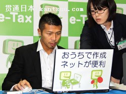 定申告が始まり、ホームページからの申告書作成を体験するボクシングの内山高志選手(16日、埼玉県春日部市)=共同