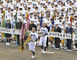 第87回選抜高校野球大会の開会式で、優勝旗を返還する龍谷大平安の江口時矢主将(21日、甲子園球場)=共同
