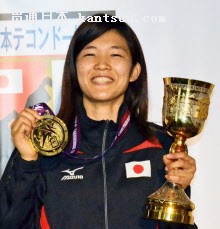 テコンドーの世界選手権の金メダルとトロフィーを手に笑顔を見せる浜田真由(21日、東京都渋谷区)=共同
