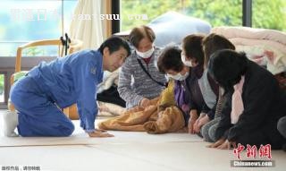 当地时间2016年4月23日,日本首相安倍晋三前往熊本县南阿苏村临时安置点激励灾民。